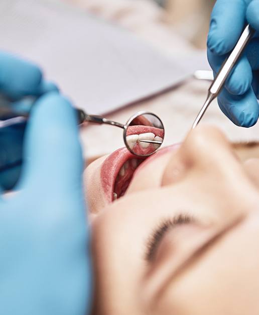 A dentist closely examining a patient’s teeth